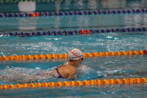 An athlete swimming breast stroke comes up for air